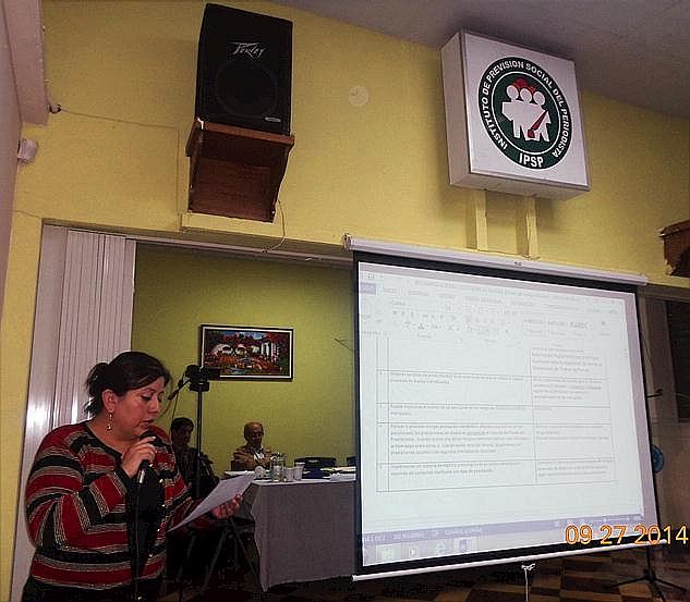 Lucía Dubón López, presidenta del Consejo Directivo del IPSP, leyendo uno de los a+rtículos de reglamento cuyo contenido es proyectado a los asambleístas en la pantalla retráctil (Foto, por Julio Trejo Pineda). 